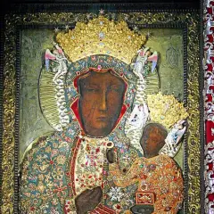 Obraz Matki Boskiej Częstochowskiej w bogatych szatach, z Dzieciątkiem Jezus. Wizerunek ten, znany z Jasnej Góry, można podziwiać w określone godziny odsłonięcia.