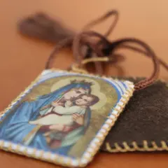 Szkaplerz kodeński z wizerunkiem Matki Bożej i Dzieciątka, symbol wiary i modlitwy.