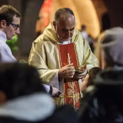 Kapłan udziela Komunii Świętej. Wierni przyjmują Ciało Chrystusa, co jest ważnym momentem po spowiedzi, gdy grzech ciężki został wyznany.